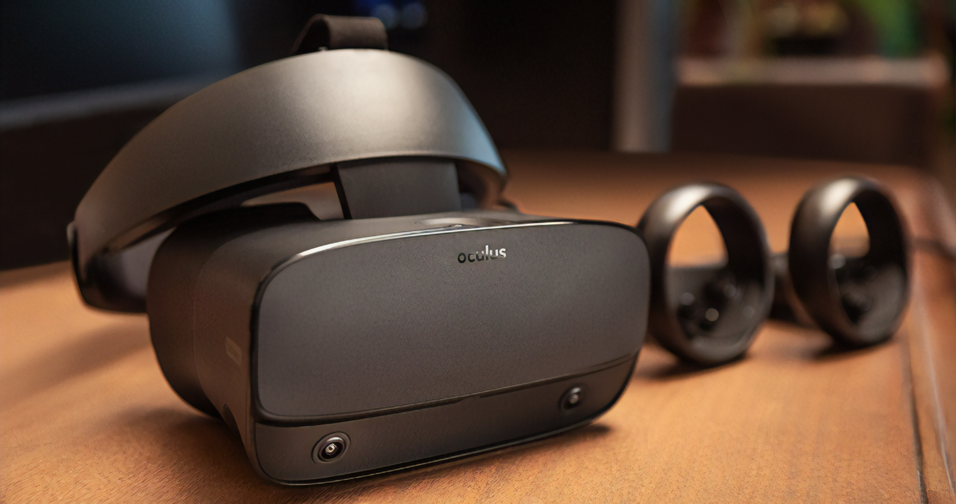 An Oculus Headset sitting on a table next to two controllers.